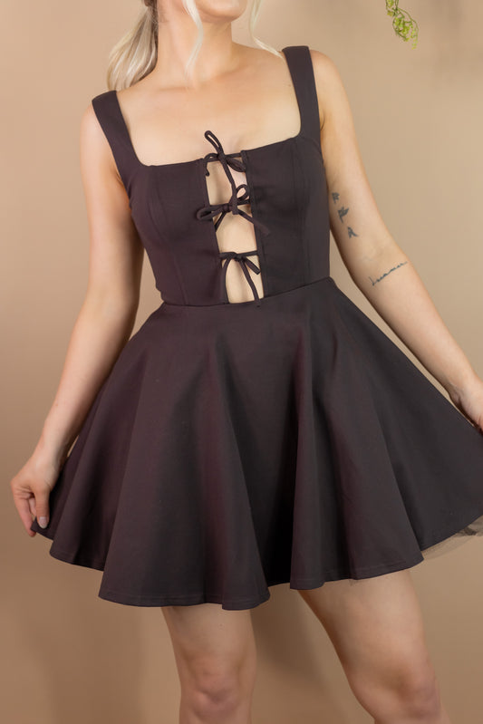 Woman's short fit and flare brown dress with cutout panel and three bow ties