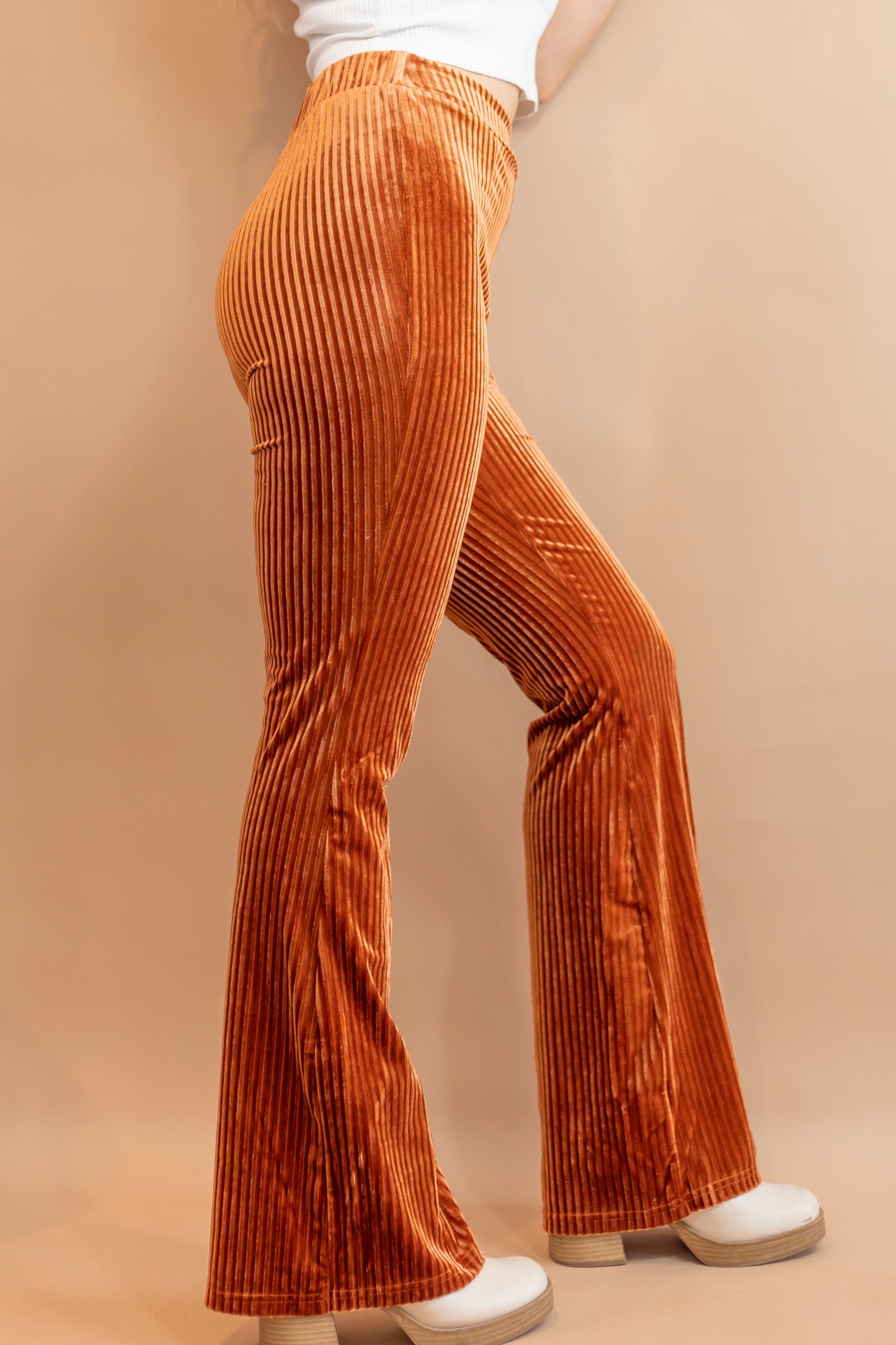 Woman's copper stretchy corduroy flare pants side view